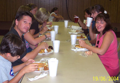 Angela, her husband, Steve, and their son, Capers sit down to fried catfish and hushpuppies!